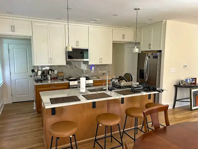 Kitchen with light-colored cabinets, stainless steel appliances and an island with seating.