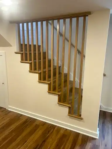 Wood staircase with vertical railing spindles and white trim.